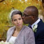 2 people looking at the camera smiling as they get married